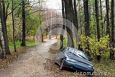 Abandoned in the woods dark blue car. Stolen auto with no license plate left in the Park. Car with a criminal history is broken Stock Photo