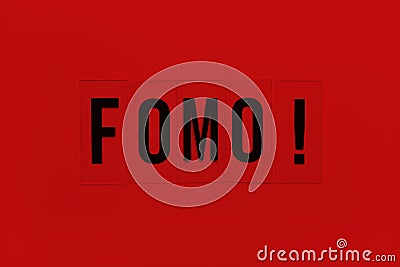 Abbreviation word FOMO on transparent plastic on red background. It means Fear Of Missing Out, non-stop internet surfing. Concept Stock Photo