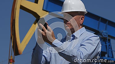 Petroleum Engineer Working in Extracting Oil Industry Text Using Mobile Stock Photo