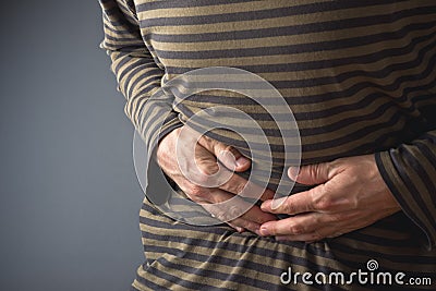 Abdominal Pain. Man holds his stomach and has hurt Stock Photo