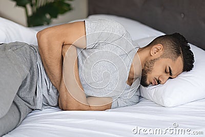 Abdominal Pain. Young Arab Man Suffering Stomach Ache At Home Stock Photo