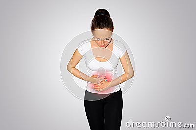 Abdominal pain. A young woman suffers from pain in the abdomen. The problem with digestion. The problem of women`s health, the co Stock Photo