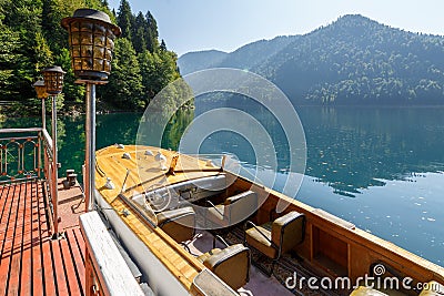 Beautiful vintage speed boat is moor at the pier on Lake Ritsa. View of the fore part of boat Editorial Stock Photo