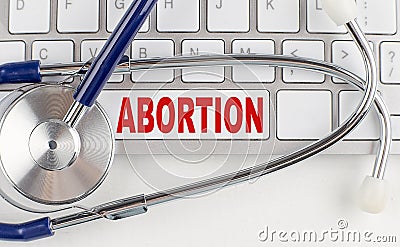 ABORTION word with Stethoscope on keyboard on grey background Stock Photo