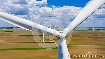 Above close view on large wind power turbine as standing among agricultural fields, generating clean renewable electrical energy Stock Photo