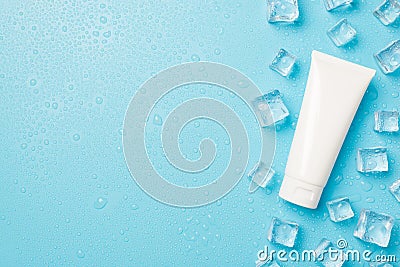 Above photo of transparent cubes ice drops and white tube of cream isolated on the blue background with copyspace Stock Photo
