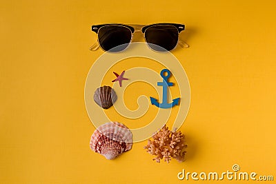 From above shot of sunglasses composed with seashells on yellow Stock Photo