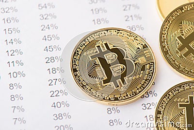 Above top close up view photo of golden shiny bitcoin laying on numbers with percentage ont he backgroundAbove top close up view Stock Photo