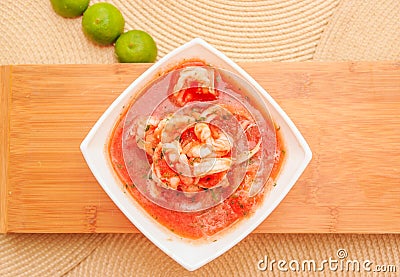 Above view of delicious traditional ecuadorian shrimp cebiche in rectangular white bowl, with lemon, served over a Stock Photo