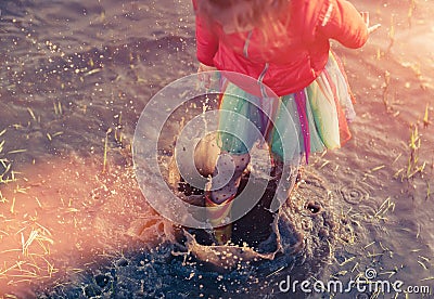 Crop girl playing in muddy puddle Stock Photo