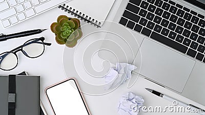 Above view messy workspace with laptop computer, smart phone, notebook and crumpled paper. Stock Photo