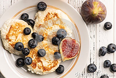 Above view of tasty breakfast: cheese pancakes with blueberry and figs Stock Photo