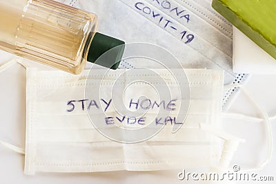 Turkish Cologne bottle,soaps and disinfectant around of medical face masks with `stay home,evde kal`writing on it, Stock Photo