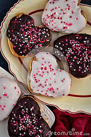 Chocolate and vanilla heart donuts with tiny red heart sprinkles on top Stock Photo