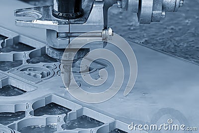 The abrasive waterjet cutting machine cutting the metal plate in the light blue scene Stock Photo