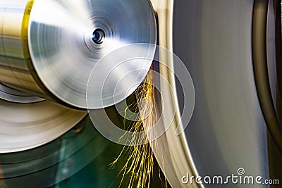 An abrasive wheel performs the grinding of a part on a circular grinding machine with sparks Stock Photo