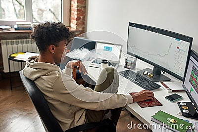 Absent-minded african american broker vaping while watching data index chart stock market Stock Photo