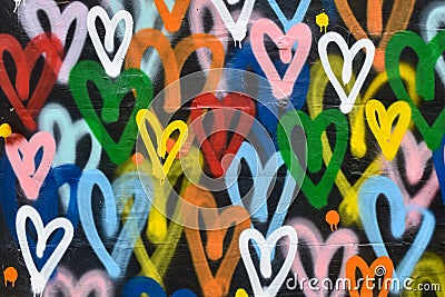 Abstract background with multicolored hearts painted with paint. The wall is brightly painted with a pattern in the form of hearts Stock Photo