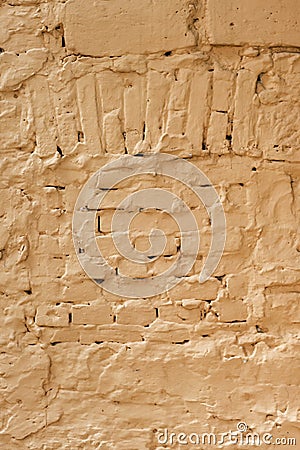 Abstract background, old plastered brickwork with a blocked window, dirty yellow background. Image for adding a text message. Stock Photo