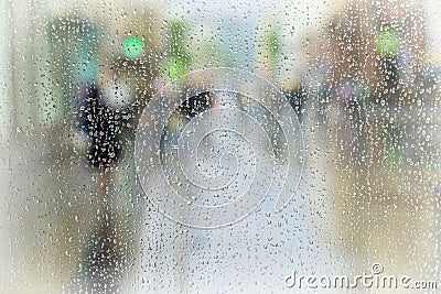 Abstract background of people hurrying down the city street in rainy day. Intentional motion blur. Concept of seasons Stock Photo