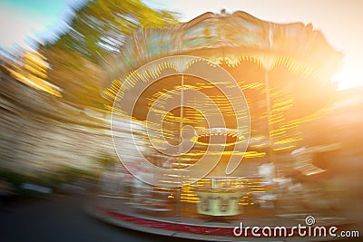 Abstract background. Rotating classic style carousel on Montmartre in backlit evening sunset sunbeam . Motion blur effect Editorial Stock Photo