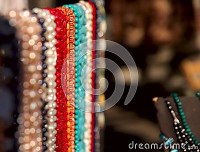 Abstract background. Samples of colorful female jewelry beads made of stone on bokeh background. Stock Photo