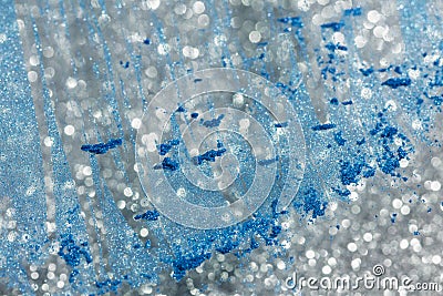 Abstract background with silver defocused glitter effect and blue powder on glass Stock Photo