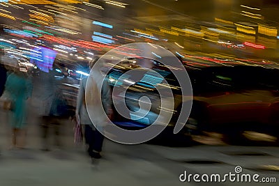 Abstract background. Street, girl with a backpack back to us and other people Near the parking lot, motion blur. Concept Stock Photo