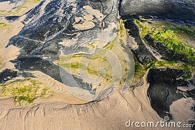 Almost abstract background of swirls of string algae and sand and rock at the oceans edge - top view Stock Photo