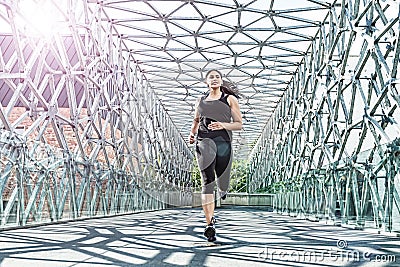 Abstract - Beautiful woman running on a modern metal bridge Stock Photo