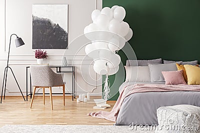 Abstract black and white painting on grey wall of elegant bedroom interior with cozy bed with pillows and blanket Stock Photo