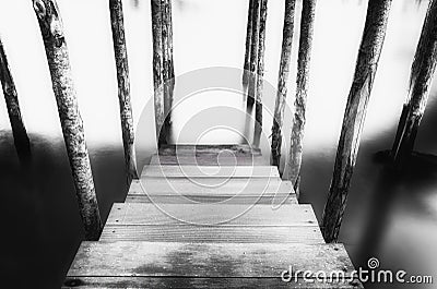 Abstract black and white picture of a wooden mooring pier and mooring piles on the Grand Canal in Venice, Italy Stock Photo