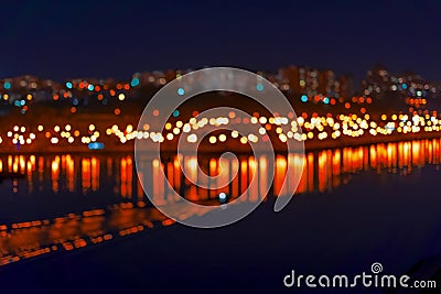 Abstract blurred bokeh of city, neon night lights, illumination, various colors in night with reflection in the lake. City life in Stock Photo