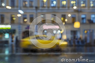Abstract blurred rainy evening . Close-up of stopped yellow taxi. Urban modern background Stock Photo