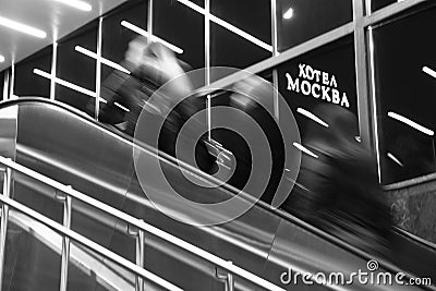 Abstract blurry people going up the subway stairs and hotel Moscow sign in the night Editorial Stock Photo