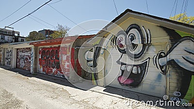 Abstract colourful fragment of graffiti paintings on garage doors. Street art composition with parts of unwritten letters and cart Editorial Stock Photo