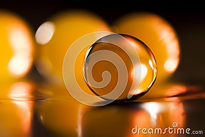 Abstract composition with beautiful, orange, transparent, round jelly balls on an aluminium foil with reflexions Stock Photo