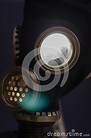 Abstract composition with a gas mask glowing from inside. Military gas mask with bright electric light in the eyepieces Stock Photo