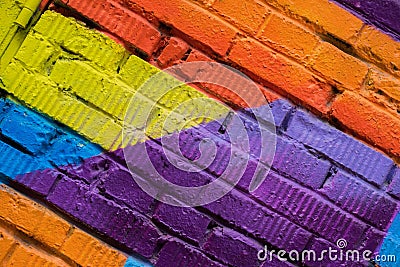 Abstract detail of brick wall with fragment of colorful graffiti, street art closeup. For backgrounds. Modern iconic Editorial Stock Photo