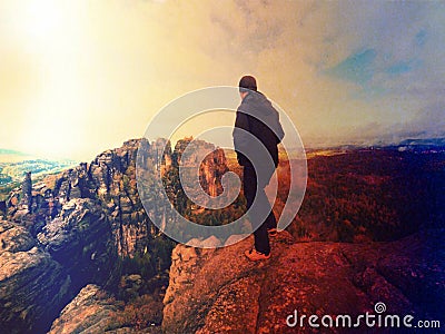 Man hiker at mountain peak. Marvelous daybreak in autumn misty landscape. Abstract effect. Stock Photo