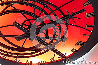 An abstract fragment of a decorative brass clockwork on a shiny red-orange background. Stock Photo