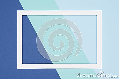 Abstract geometrical flat lay pastel blue and turquoise colored paper background. Minimalism template with empty picture frame. Stock Photo