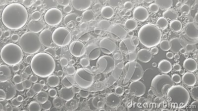 Abstract image of numerous transparent bubbles varying in size, floating against a gray backdrop Stock Photo