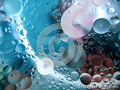 Abstract image of oil and water in a glass bowl sitting on a colorful surface Stock Photo