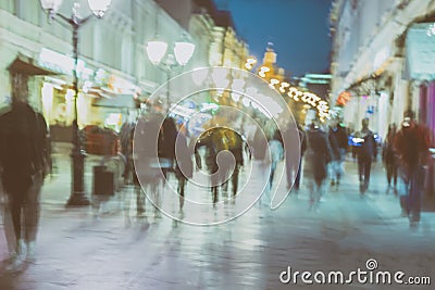 Abstract image of unrecognizable silhouettes of people walking in city street in evening, nightlife. Urban modern Stock Photo