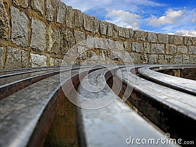 Abstract metal bench rails seating brick wall Stock Photo