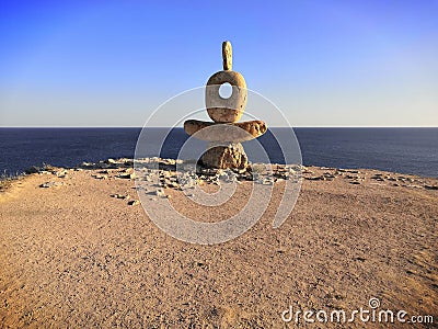 Abstract modern sculpture called "A wise man" on a sea cliff, Crimea. Stock Photo