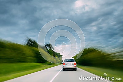 Abstract Natural Blurred Background Of Luxury Suv Car In Fast Motion On Road At Summer. Cloudy Sky Above Asphalt Stock Photo