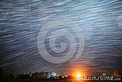 Abstract Night Starry Sky Above Village. Sky Background Over Rural Countryside Landscape. Meteors Cross Dark Blue Sky Stock Photo