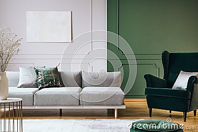 Abstract oil painting on grey wall with moldings in contemporary living room interior with grey long couch Stock Photo